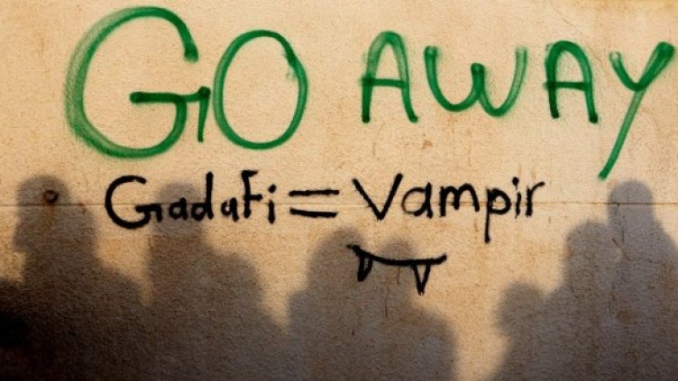 Демонстранти се събират близо до графит срещу Кадафи на площада в Тобрук. Снимка: Ройтерс