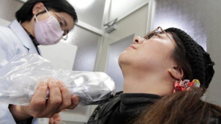 Лекар изследва жител на Фукушима за радиация. Снимка: Reuters