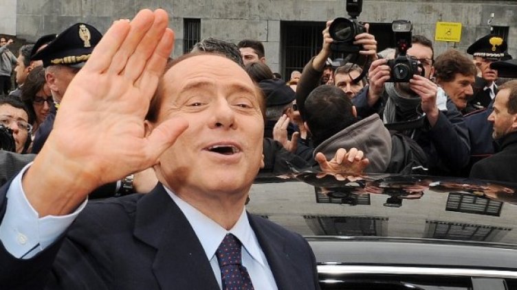 Берлускони маха на събралите се пред съда репортери. Снимка: БТА