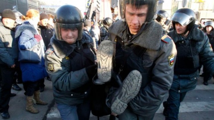 Полицаи "изнасят" един от активистите в Москва. Снимка: Reuters