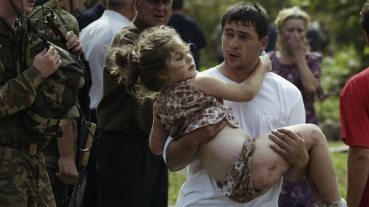 Доброволец изнася ранено дете, след като руските спецчасти щурмуваха училището в Беслан на 3 септември 2004 г. Снимка: Getty Images/Guliver Photos