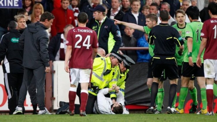 Полицаи арестуват нападателя на Нийл Ленън на мача между Селтик и Хартс. Снимка: Reuters