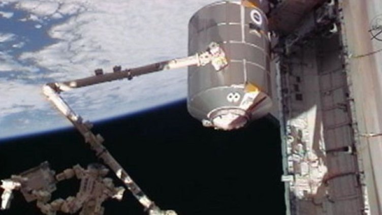 Роботизираната ръка на станцията – Canadarm2, изважда модула "Рафаело" от товарния отсек на "Атлантис". Снимка: NASA TV