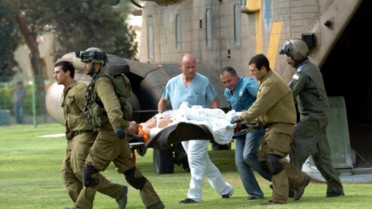 Израелски войници и лекари изнасят войник, ранен край курорта Ейлат по време на атака на автобус, превозвал войници. Снимка: Reuters