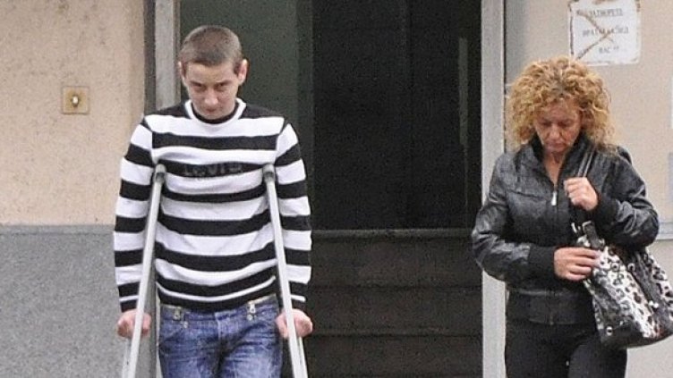 Данаил Георгиев се придвижва с патерици, придружен от майка си. Снимка: Булфото