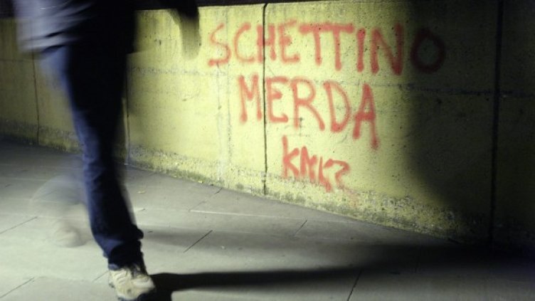 Мъж минава покрай надпис на стена "Скетино лайно" в Гросето. Снимка: Reuters