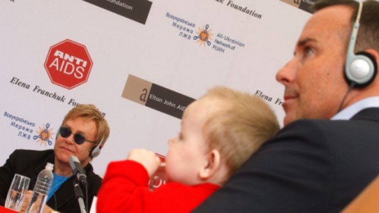 Елтън Джон слуша въпрос, а неговият партньор Фърниш държи бебе на пресконференция, 2009 г. Снимка: архив, Reuters