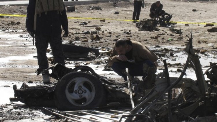 Полицай оглежда останките от автомобил, използван за бомбено нападение в град Хила. Снимка: Reuters