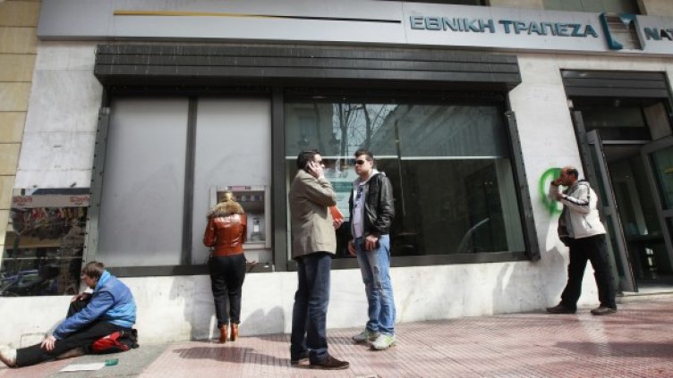 Мъж проси пред клон на банка в Атина. Снимка: Ройтерс