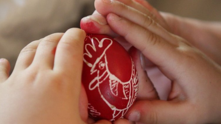 С първото червено яйце направете кръст на челото на детето. Снимка: Булфото