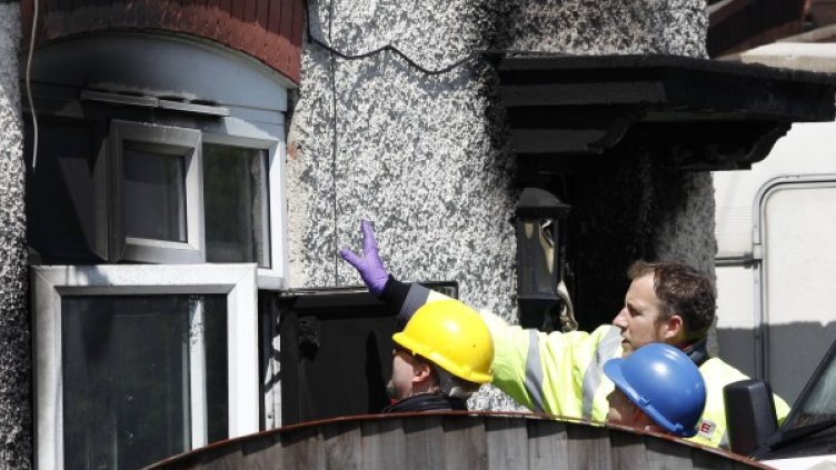 Пожарникари оглеждат къщата, в която загинаха пет деца. Снимка: Reuters