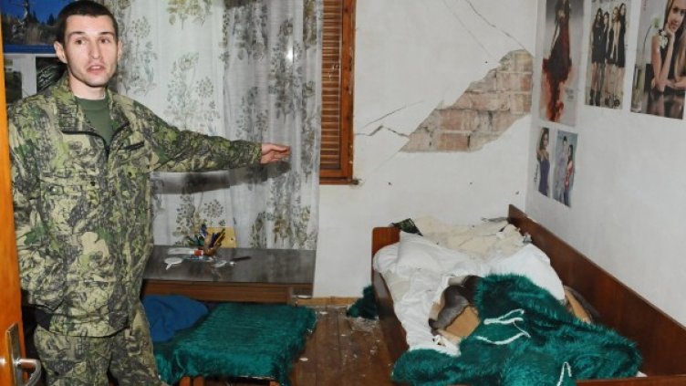 Момче показва пораженията от земетресението в къщата му в Рударци. Снимка: Булфото
