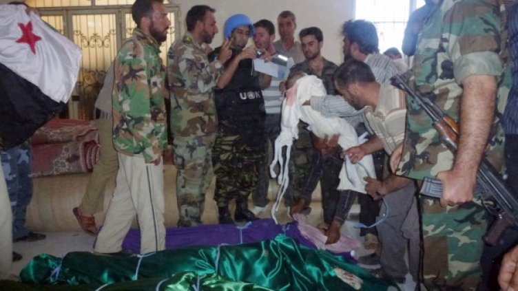 Мъже от Хула показват тялото на дете на наблюдател на ООН. Снимка: Reuters