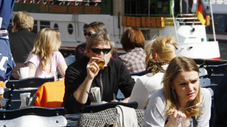 Хора се наслаждават на пролетното слънце в кафене на брега на река Шпрее в Берлин. Снимка: архив, Reuters