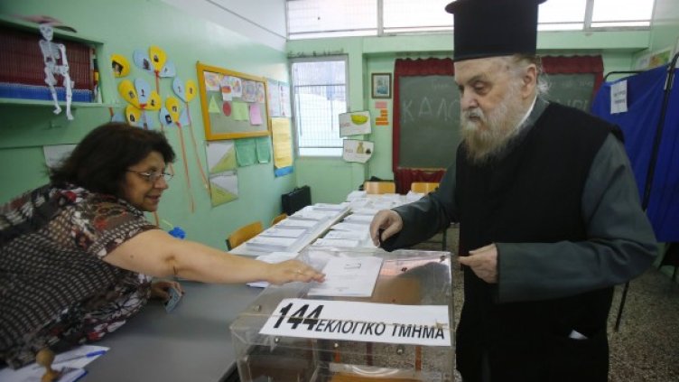 Свещеник дава своя глас за нов парламент на Гърция. Снимка: Reuters