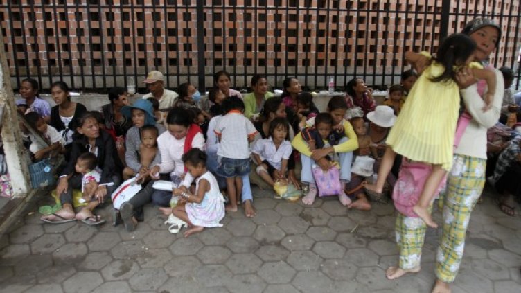 Хора чакат с децата си за безплатно лечение в болница в Пном Пен. Снимка: Reuters