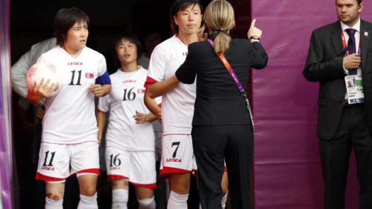 Служители по сигурността на стадиона в Глазгоу се опитват да успокоят бесните футболистки от Северна Корея. Снимка: Reuters