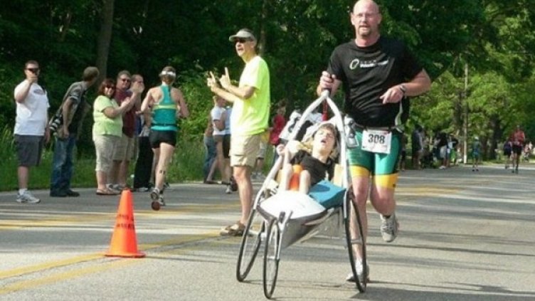 Рик ван Бийк бута дъщеричката си Меди по време на бягането от триатлона. Снимка: Facebook