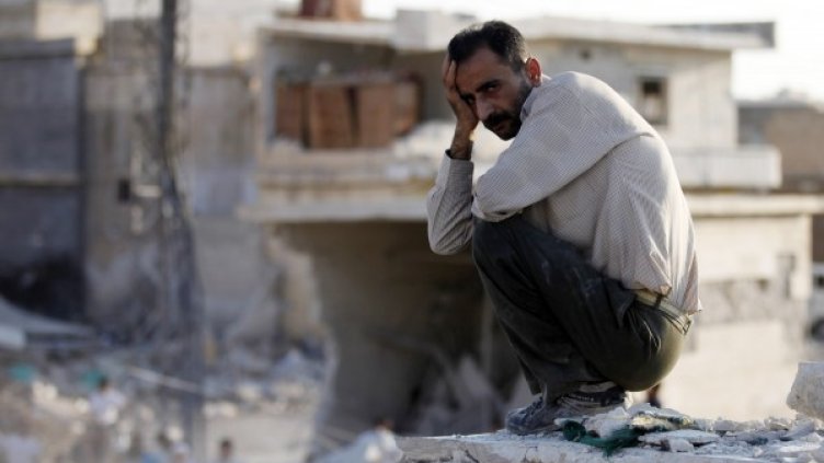Сириец от градчето Азас, намиращо се на 47 км от Алепо, не може да повярва, че къщата му е разрушена. Снимка: Reuters