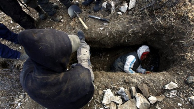 Дупките, в които монголските миньори търсят злато извън закона, приличат на техни гробове. Снимка: Reuters