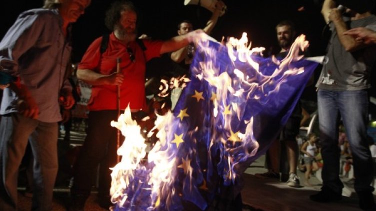 Протестиращи в Солун горят знаме на ЕС. Снимка: Reuters