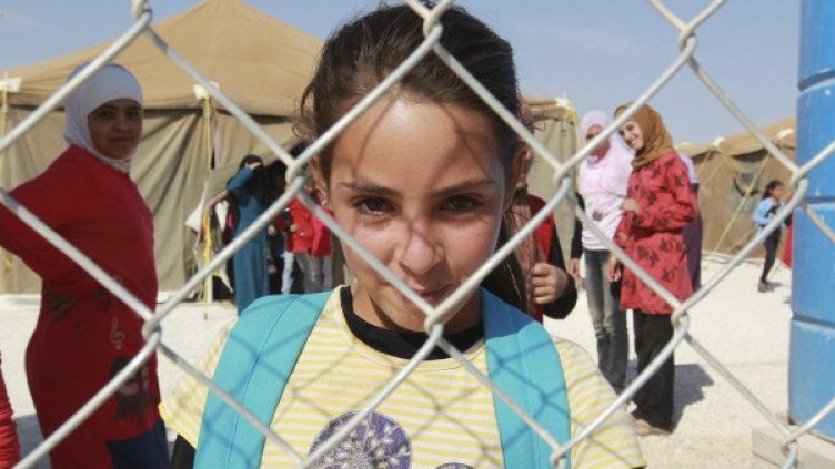 Момиченце гледа през оградата на лагера Заатари. Снимка: Reuters