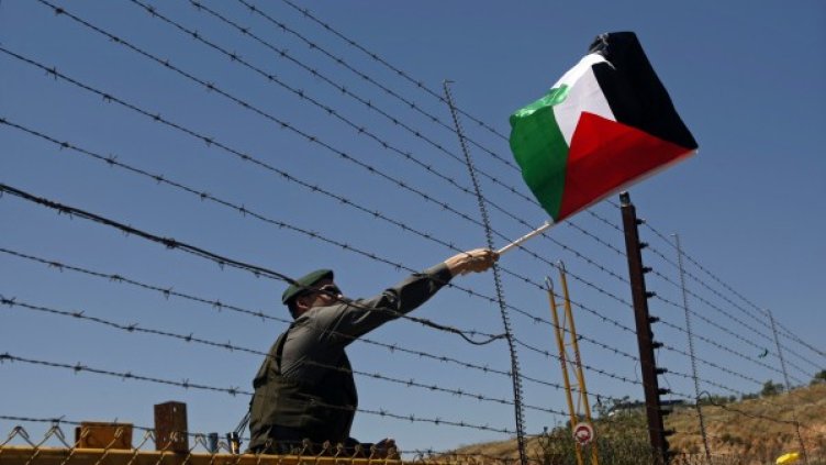 Израелски граничен полицай свяла палестинското знаме. Снимка: архив, Reuters