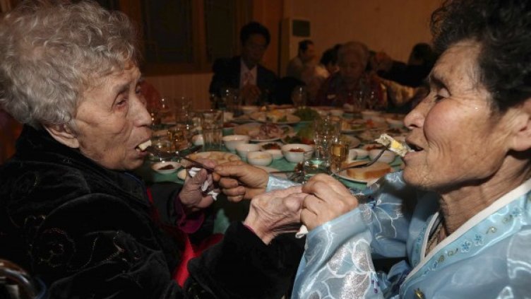 Майка от Южна Корея (в ляво) и дъщеря й от Северна Корея се хранят. Снимка: Reuters