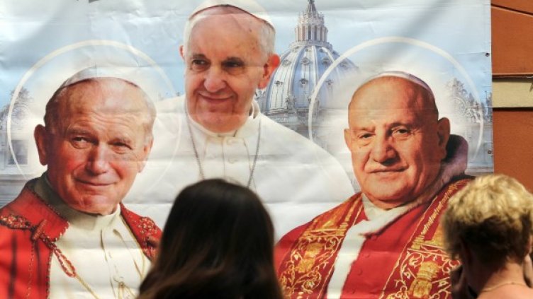 Плакат с ликовете на папа Йоан Втори, папа Франциск и папа Йоан Двадесет и трети. Снимка: Reuters