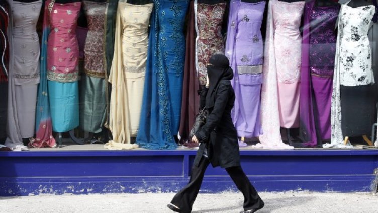 Жена минава покрай магазин за дрехи в Бирмингам. Снимка: архив, Reuters