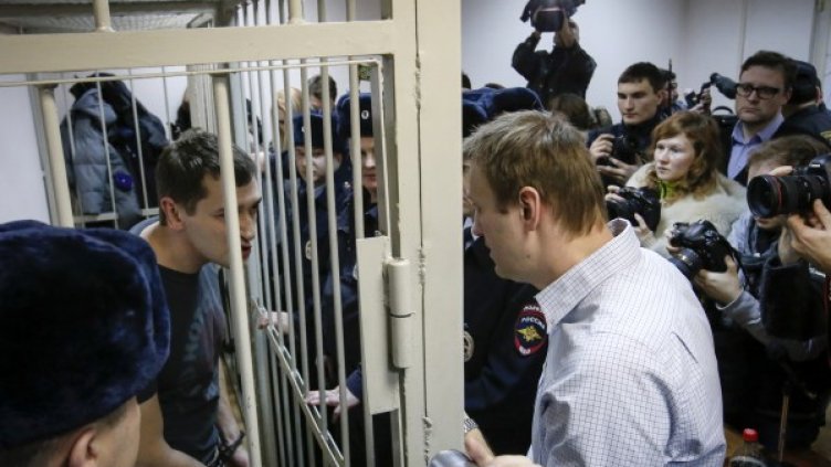 Алексей Навални /дясно/ разговаря с брат си Олег /зад решетките/. Снимка: Reuters