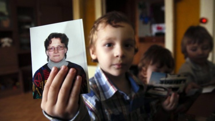 Едно от децата със снимка на майка си Светлана Давидова. Снимка: Reuters