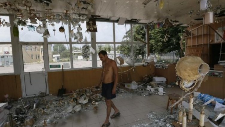 Собсвеник на магазин за осветителни тела оглежда бомбардирания си магазин. Снимка: Reuters