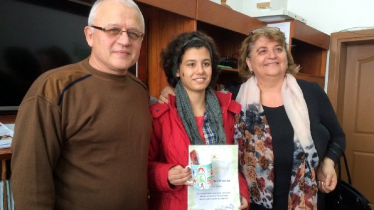 Мария получава грамотата си. До нея са директорите на училището и на дома. Снимка: БТА