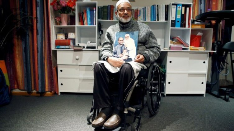 Ахмед държи снимка със съпругата му Хусна. Снимка: Reuters