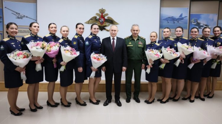 Путин и Шойгу с випускнички на Краснодарското висше военно авиационно училище, след като са им поднесли букети с цветя по случай 8 март.Снимка: БГНЕС