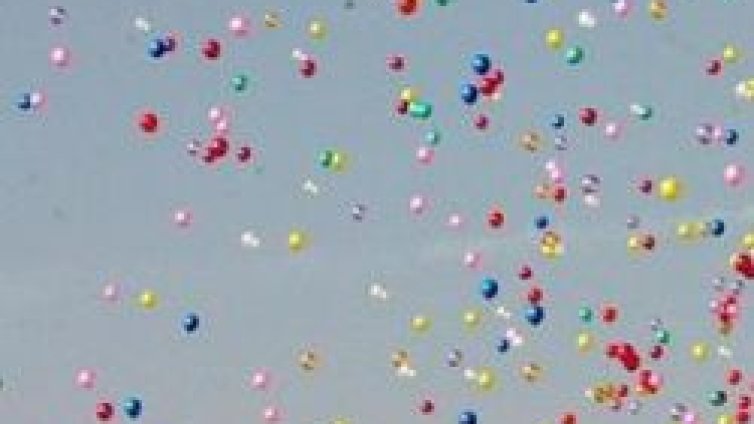 Ентусиаст летя в кресло, носено от балони