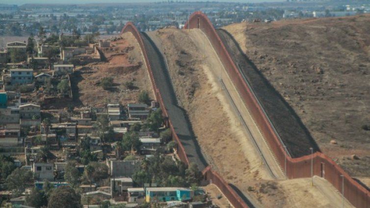 Мъж пусна две малки деца от 4-метрова стена между САЩ и Мексико
