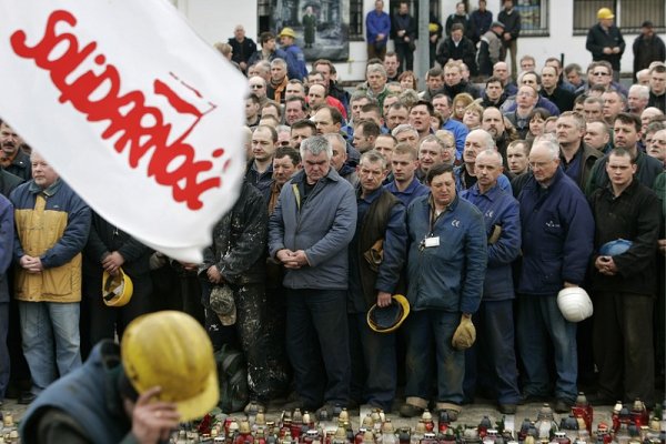 Работници от корабостроителницата в Гданск със знамена на &bdquo;Солидарност&ldquo; отдават почит на жертвите на самолетната катастрофа пред паметника на загиналите корабостроители през 1970 година. Снимка: БГНЕС