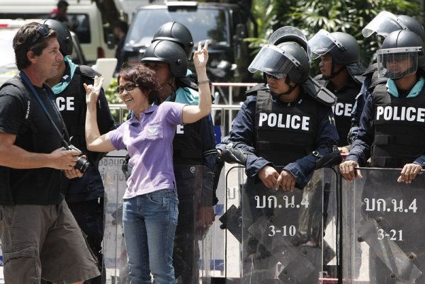 Туристка се снима на фона на тайландски войници, охраняващи петзвезден хотел в Банкок заради политическите размирици в страната. От началото на протестите потокът от туристи към страната е намалял драматично. Снимка: БГНЕС