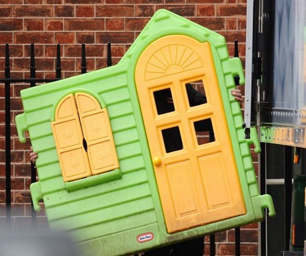 Служител изнася детска къщичка от двора на Даунинг стрийт 10. Във вторник Гордън Браун подаде оставка като премиер на Великобритания и отстъпи мястото на победителя в изборите &ndash; консерватора Дейвид Камерън. Снимка: БГНЕС