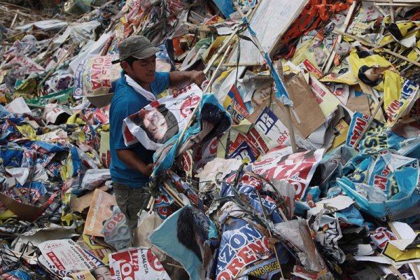 Филипински работник събира предизборните плакати в Манила след изборите преди два дни. Снимка: БГНЕС 

&nbsp;