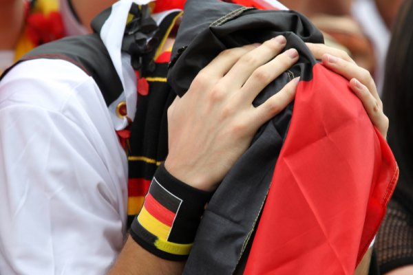 Германски фен е покрил главата си със знамето на своята страна след изненадващата загуба на Бундестима от Сърбия с 0:1. Снимка: Getty Images/Guliver Photos