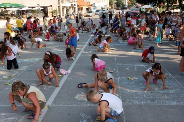 Деца от България, Германия, Русия, Франция и Украйна, почиващи със своите родители в Бяла, рисуваха на асфалта пред общината в рамките на Седмицата на морето. Снимка: БГНЕС