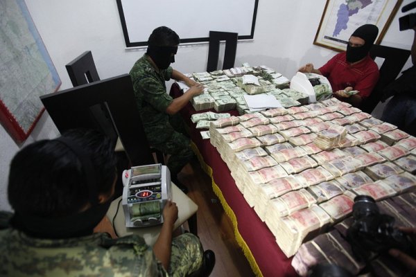 Войници от мексиканската армия броят 1,3 милиона долара, задържани при операция в Монтерей, Мексико. Военен патрул разпознал издирван наркотрафикант на улицата и след като го последвали, стигнали до къща, където шест души увивали парите в пликове. Снимка: БГНЕС