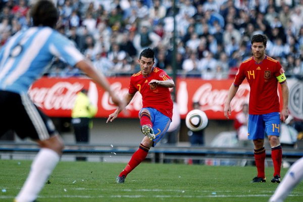 Испанският нападател Давид Вия стреля пред погледа на своя сънародник Шаби Алонсо по време на контролната среща срещу Аржентина в Буенос Айрес. Европейските и световни шампиони загубиха с 1:4 от южноамериканците. Снимка: БГНЕС