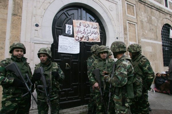 Тунизийски военни охраняват канцеларията на министър-председателя. Според местни медии стотици протестиращи са изкарали нощта пред сградата с искане за оставка на правителството. Снимка: БТА