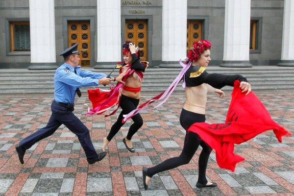 Украински полицай се опитва да арестува представителка на ФЕМЕН по време на поредния протест пред парламента в столицата Киев. Този път те изразиха недоволството си срещу пенсионната реформа в страната. Снимка: БТА