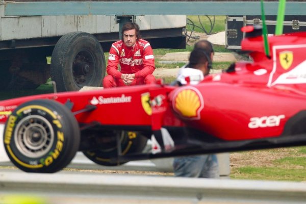 Испанският пилот на Ферари &ndash; Фернандо Алонсо, гледа тъжно своя автомобил след инцидент по време на първата свободна тренировка преди неделното Гран при на Индия. Снимка: БТА