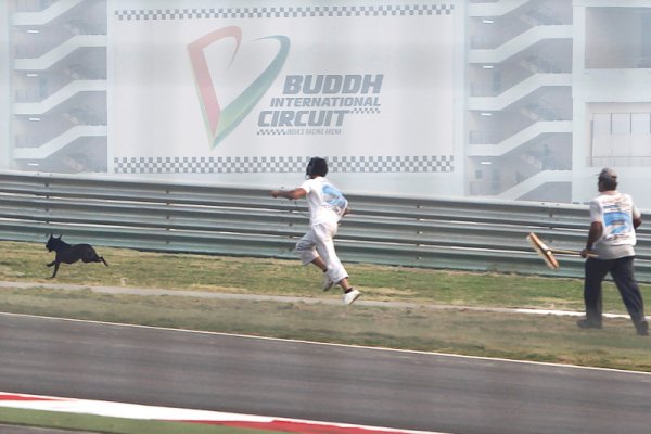 Маршалите на състезанието в Индия гонят куче по пистата по време на първата свободна тренировка. Няколко бездомни четириноги създадоха сериозни проблеми на организаторите на състезанието с появата си на пистата. Снимка: Reuters